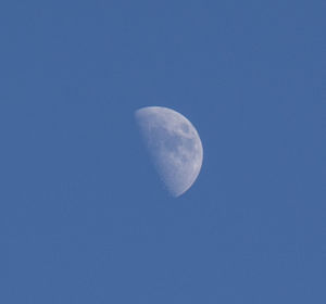 Low angle view of moon against blue sky