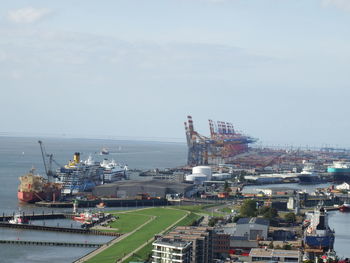 High angle view of commercial dock by sea against sky