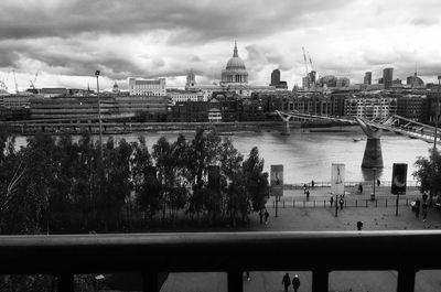 View of bridge in city against cloudy sky