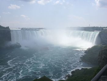 Scenic view of waterfall against sky