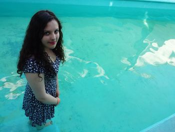 Portrait of young woman standing in swimming pool