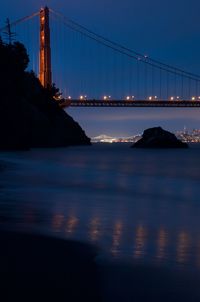 View of suspension bridge in city at night