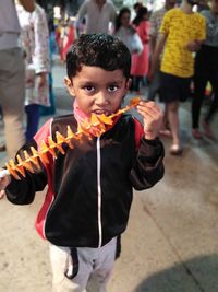 Portrait of boy standing on street in city