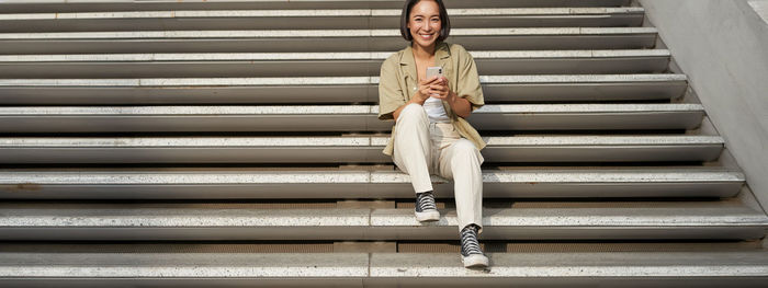 Full length of woman standing on staircase