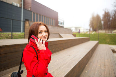 Portrait of woman standing on mobile phone in winter