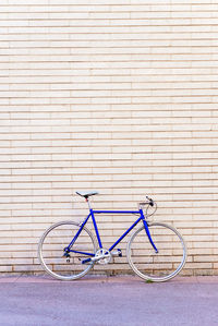 Vintage blue bike leaning on a city brick wall