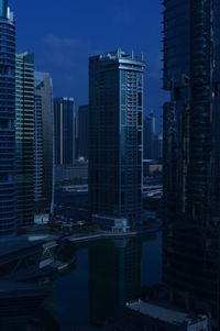 Modern buildings in city against sky at dusk