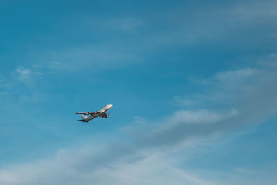 Low angle view of airplane flying against sky