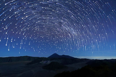 Scenic view of mountains against sky at night