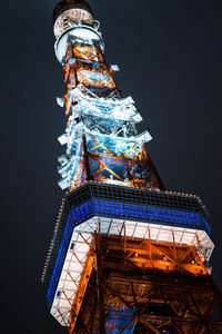 Low angle view of illuminated tower against sky at night