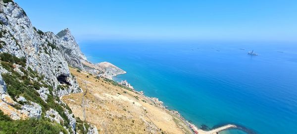 High angle view of rocks by sea against clear sky