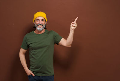 Rear view of man standing against yellow background