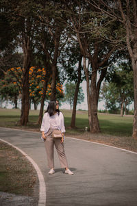 Rear view of woman walking on road