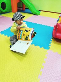 High angle view of boy sitting on book