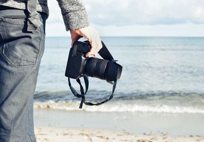 Man photographing camera on beach