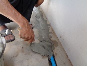 Low section of man working on concrete wall