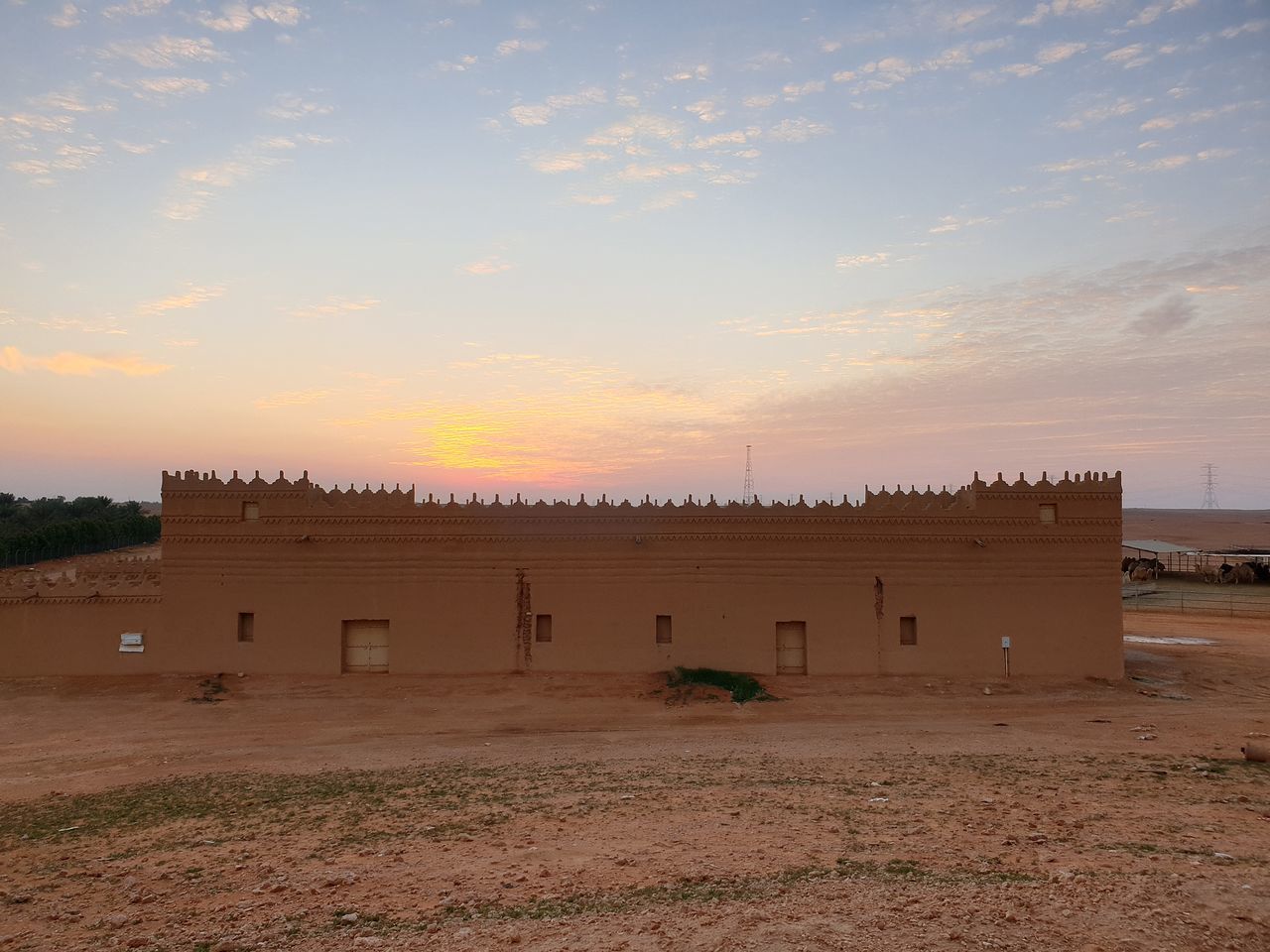 CASTLE ON FIELD AGAINST SKY DURING SUNSET