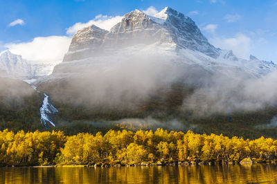 Mountains with fresh snow above autumn landscape autumn colors