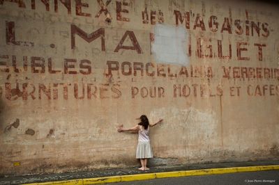 Full length of woman standing against wall