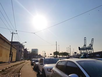 Cars on road against sky on sunny day