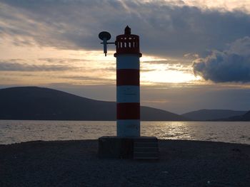 Lighthouse at seaside during sunset