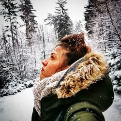 Portrait of woman looking at snow covered land