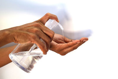 Close-up of man holding glass over white background