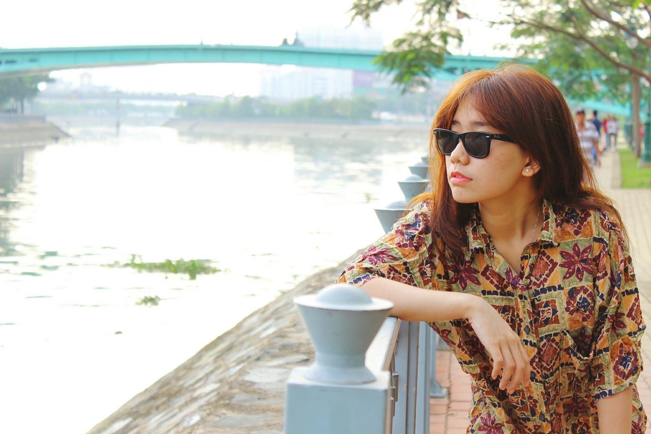 young adult, person, young women, water, lifestyles, leisure activity, sunglasses, portrait, looking at camera, smiling, long hair, casual clothing, focus on foreground, river, lake, waist up, standing