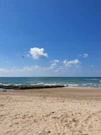 Scenic view of beach against blue sky