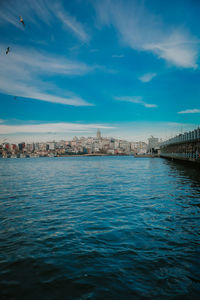 View of buildings in sea against cloudy sky