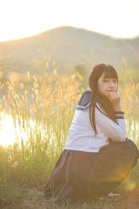 Young woman sitting on field