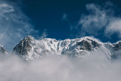 Low angle view of snowcapped mountains against sky