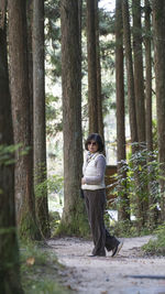 Rear view of woman standing in forest