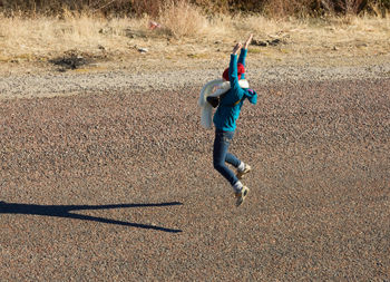 Happy girl jumping over street