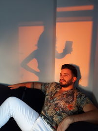 Young woman sitting on sofa at home