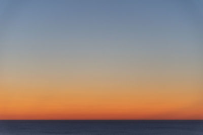 Scenic view of sea against clear sky during sunset