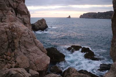 Scenic view of rocks in sea against sky