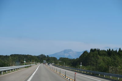 Road leading towards mountain against sky