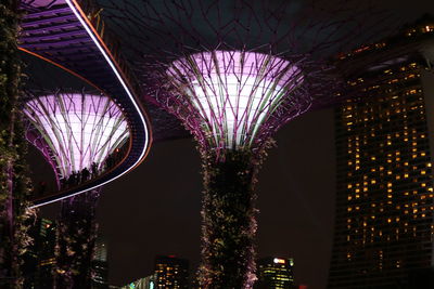 Low angle view of illuminated buildings against sky at night