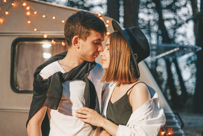 Young couple standing by car