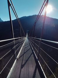 Low angle view of suspension bridge against sky