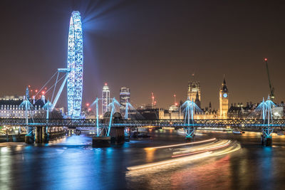 Illuminated bridge over river at night