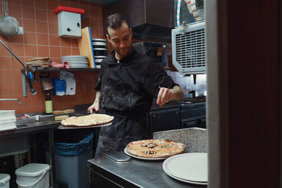 Fresh italian pizza making process. man making pizza at the kitchen