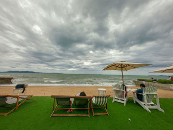 Chairs on beach against sky