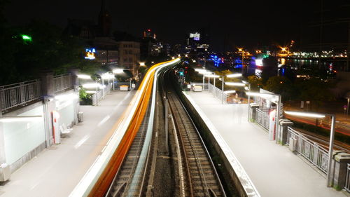 Railroad tracks in city at night