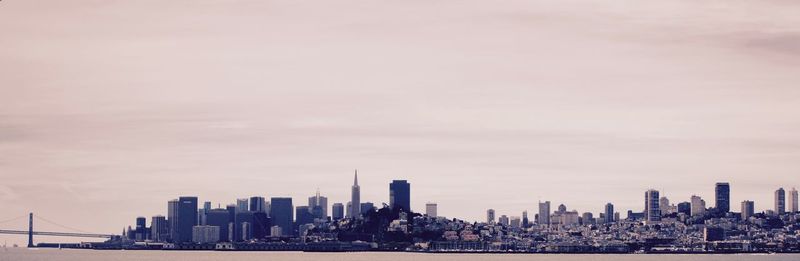 River with cityscape against clear sky