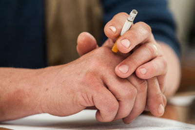 Close-up of man hand holding cigarette