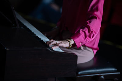 Midsection of man playing piano