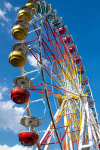 Low angle view of ferris wheel against blue sky