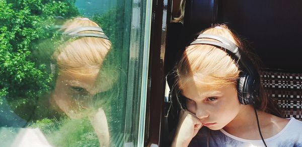 Portrait of girl looking through window